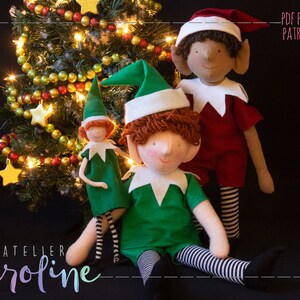 May include: Three handmade elf dolls, one with red and white striped legs, one with green and white striped legs, and one with black and white striped legs. The dolls are sitting in front of a Christmas tree with gold and red ornaments. The text "PDF PATTERN PATRON PDF" is in the upper right corner of the image.
