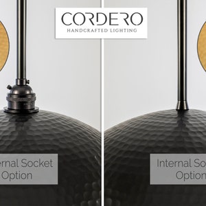 May include: Two black metal pendant lights with hammered metal shades. The left light has an external socket, while the right light has an internal socket.  CORDERO HANDCRAFTED LIGHTING is printed above the lights.