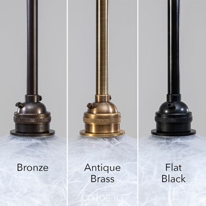 May include: Five different finishes for a pendant light fixture. The finishes are brushed brass, bronze, antique brass, flat black, and brushed nickel.