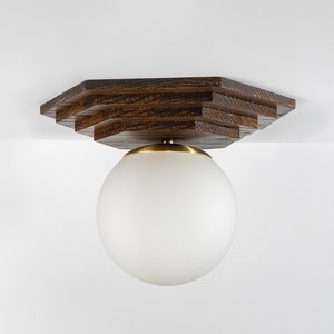 May include: A ceiling light fixture with a white globe shade and a wooden octagonal base.