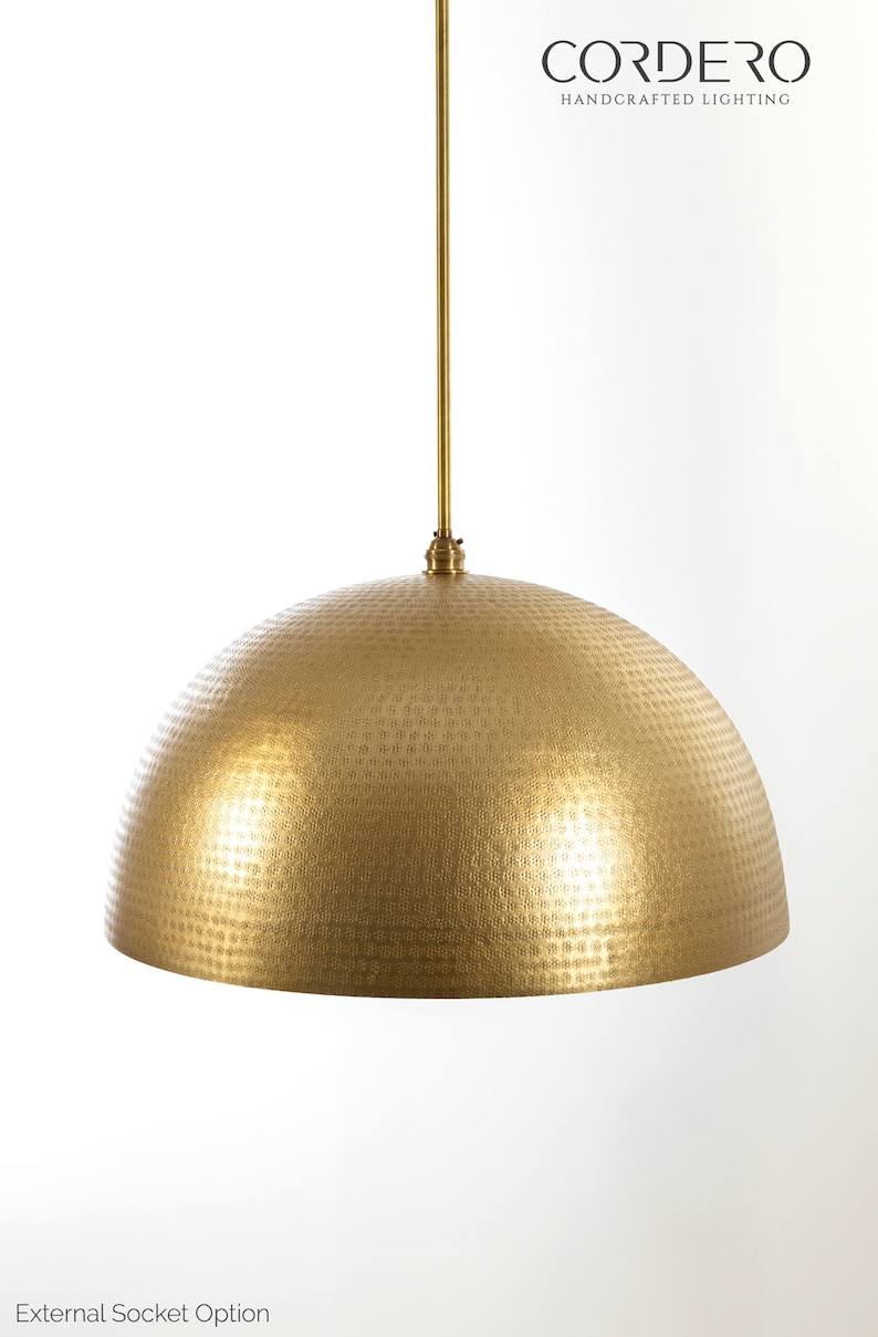 May include: A gold hammered metal dome pendant light fixture with a long, straight rod hanging from the ceiling.  CORDERO HANDCRAFTED LIGHTING is printed in black text at the top of the image.