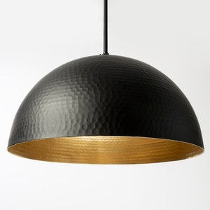 May include: A black hammered metal dome pendant light with a gold interior.