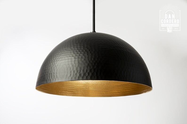 May include: A black hammered metal dome pendant light with a gold interior.