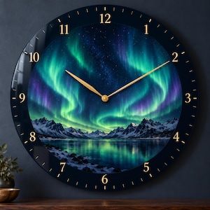 Pode incluir: Um relógio de parede redondo com uma imagem vibrante de auroras boreais sobre montanhas nevadas e um lago refletor. O mostrador tem uma borda escura com números dourados de 1 a 12 e ponteiros finos de cor dourada.