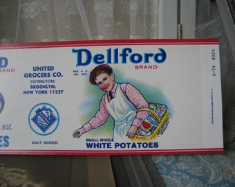 May include: A vintage Dellford brand potato bag with a red, white and blue colour scheme. The bag features a cartoon illustration of a boy holding a basket of potatoes. The text on the bag reads "Dellford Brand", "United Grocers Co.", "Distributors Brooklyn, New York 11227", "Small Whole White Potatoes", "Salt Added", and "Selected Quality".