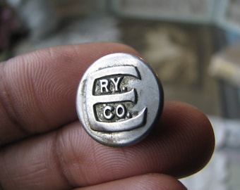 May include: A silver metal button with the text "E. RY. CO." embossed on it.