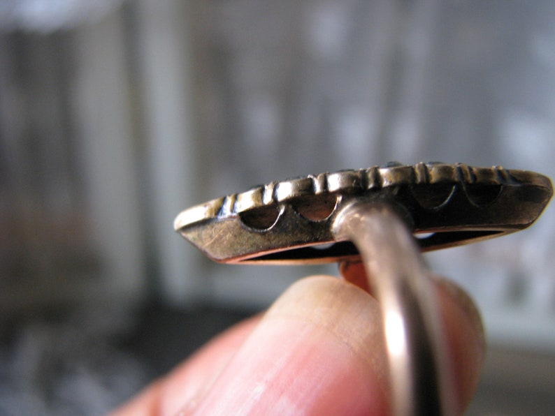 Puede incluir: Un anillo de oro con un dise&ntilde;o detallado y una banda lisa. El anillo est&aacute; engastado con una piedra preciosa redonda grande.