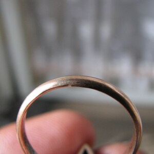 Puede incluir: Primer plano del interior de un anillo de oro. El anillo es liso y brillante.