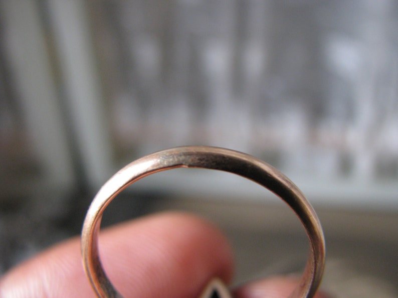 Puede incluir: Primer plano del interior de un anillo de oro. El anillo es liso y brillante.