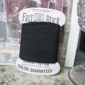 May include: A spool of black "Tiger" Fast Black darning cotton. The label says "Wash with Ivory Soap" and "Color Guaranteed".