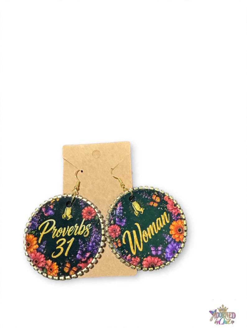 K&ouml;nnte beinhalten: Runde H&auml;ngeohrringe mit dunkelgr&uuml;nem Hintergrund und bunten Blumen- sowie Schmetterlingsmustern. Der linke Ohrring zeigt den Text Proverbs 31 in goldener Schrift, w&auml;hrend der rechte Ohrring das Wort Woman in goldener Schrift zeigt.