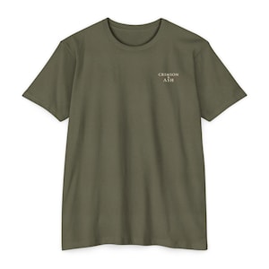 May include: An olive green short-sleeve t-shirt with a crew neckline. The upper left chest area features the text "CRIMSON & ASH" printed in a small, light-colored font. The garment is displayed flat against a plain, neutral background.