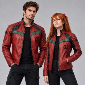 Könnte beinhalten: Eine rote Lederjacke mit schwarzen Schulterpartien, einem horizontalen grünen Streifen auf der Brust und der in Schwarz aufgedruckten Nummer 02 auf der linken Seite. Die Jacke hat einen Stehkragen, einen Reißverschluss und lange Ärmel.