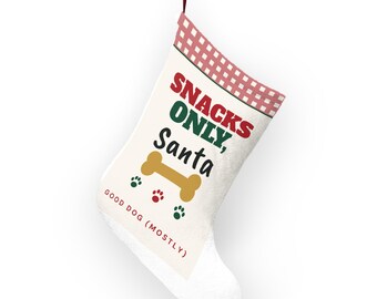 Puede incluir: Un calcetín navideño blanco con un puño a cuadros rojos y blancos. El texto dice SNACKS ONLY, Santa en rojo y verde, con un gráfico de hueso amarillo, tres pequeñas huellas de patas y el texto GOOD DOG (MOSTLY) en letras rojas.