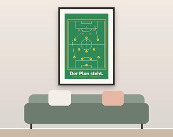 May include: A framed wall art print featuring a green soccer field diagram with yellow player circles, red opponent crosses, and white movement arrows. The text at the bottom reads Der Plan steht. Taktik - Teamgeist - Leidenschaft.