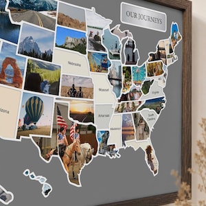 May include: A framed map of the United States with a gray background featuring a photo collage within the state borders. The text OUR JOURNEYS is printed in the upper right corner. Several states are labeled, including Nebraska, Missouri, and Arkansas.