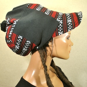 Peut inclure: Un bonnet noir et rouge à motifs avec un pompon sur le dessus. Le bonnet a une large visière et est fait d'un tissu doux et confortable.