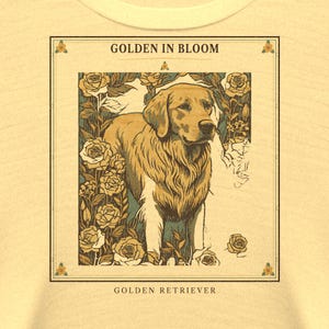 May include: A light yellow t-shirt featuring a rectangular graphic print of a Golden Retriever surrounded by roses. The text GOLDEN IN BLOOM appears at the top of the frame, and the text GOLDEN RETRIEVER is printed at the bottom of the design.