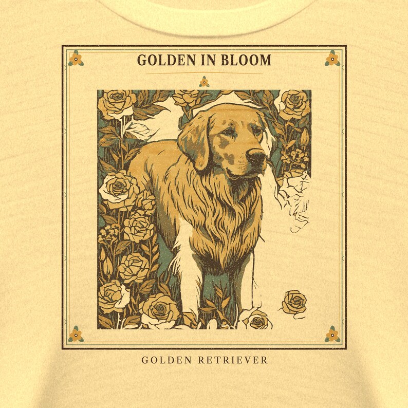 May include: A light yellow t-shirt featuring a rectangular graphic print of a Golden Retriever surrounded by roses. The text GOLDEN IN BLOOM appears at the top of the frame, and the text GOLDEN RETRIEVER is printed at the bottom of the design.