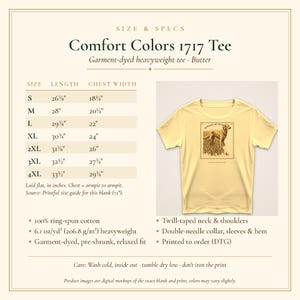 May include: A butter-colored Comfort Colors 1717 heavyweight t-shirt featuring a graphic of a Golden Retriever dog. The image includes a size chart with measurements in inches for sizes S through 4XL, fabric details, and care instructions.