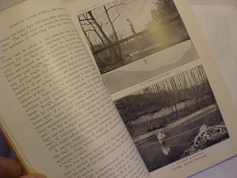 May include: A black and white image of a book with text about surface water supply. The book has two images of a stream with a person standing in the water. The text in the book discusses the importance of selecting the right location for a stream gauge.