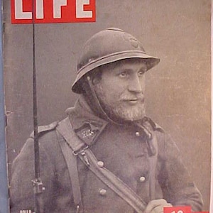 May include: A black and white photo of a soldier wearing a helmet and a uniform. The photo is from a LIFE magazine cover dated March 11, 1940. The text "POILU" is printed at the bottom left corner of the image.