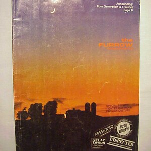 May include: A magazine cover with a sunset background and the text "the FURROW" in a white box. The magazine cover also includes the text "Announcing: Four Generation II Tractors page 9" and "SPECIAL REPORT TIGHTER CONTROLS FOR AGRICULTURE". The bottom of the cover has two stamps: "APPROVED" and "INSPECTED".