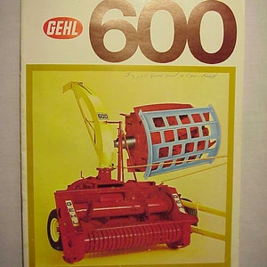 May include: A red and yellow Gehl 600 hay baler with a blue and white hay pickup. The baler has a large red roller and a yellow frame. The pickup has a blue metal cage and a yellow frame.