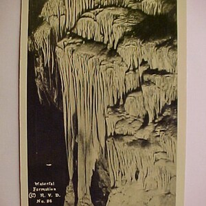 May include: Black and white vintage postcard featuring a cave formation. The image shows a waterfall formation with stalactites and stalagmites. The text on the postcard reads "Waterfall Formation" and "R. V. D. No. 86."