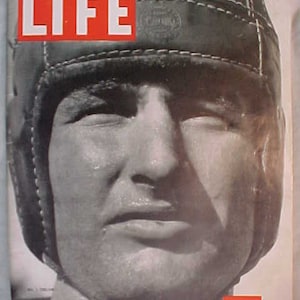 May include: A black and white photo of a man wearing a leather helmet on the cover of LIFE magazine. The magazine cover reads "LIFE" and "October 11, 1937 10 CENTS".