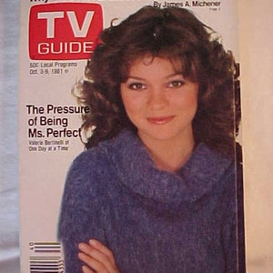 May include: A magazine cover featuring a woman with brown hair wearing a blue sweater. The magazine is TV Guide and the headline is "Why We'll Never Elect a Bald President" by James A. Michener. The sub-headline is "The Pressure of Being Ms. Perfect".
