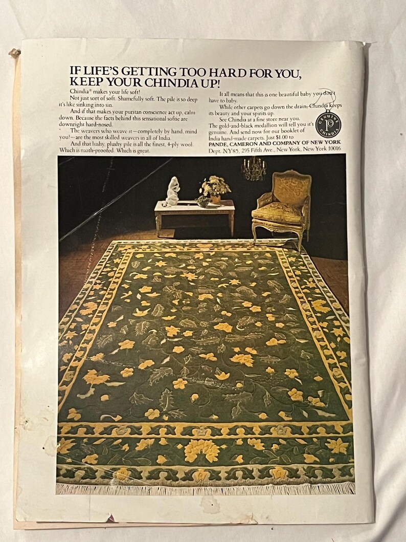 May include: An advertisement for a Chindia rug. The rug is green with yellow floral patterns and a yellow border. The text reads "IF LIFE'S GETTING TOO HARD FOR YOU, KEEP YOUR CHINDIA UP!" and includes information about the rug's quality and origin.