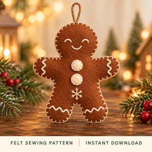 May include: A brown felt gingerbread man ornament featuring white blanket stitching along the edges, two white circular buttons on the chest, a white snowflake embroidery, and a smiling face. A brown hanging loop is attached to the top.