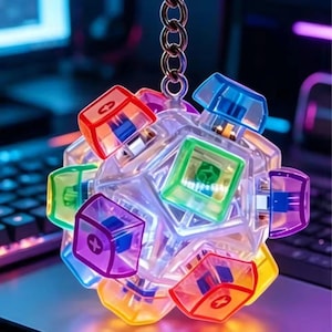 May include: A spherical fidget keychain constructed from multiple translucent, multi-colored mechanical keyboard switches. The switches feature red, green, blue, purple, and yellow plastic caps with a plus-sign stem, attached to a metal ring.