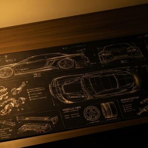 Pode incluir: Um tapete de secretária retangular preto com desenhos técnicos brancos de um carro desportivo, incluindo componentes do motor, diagramas de rodas e o texto KAZE. O design apresenta vários esquemas e especificações.