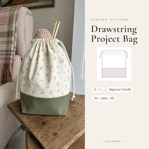 Op de afbeelding: Een naaipatroon voor een trekkoord projecttas met de tekst SEWING PATTERN Drawstring Project Bag, S-L, Beginner friendly, A4, Letter, A0 en LUXE PRIME PATTERN. De tas is crème met een groen bloemenpatroon en een groene basis.