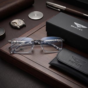 Può includere: Occhiali senza montatura con aste e ponte in metallo color argento, caratterizzati dal logo Bentley sulle lenti e sulle aste. Include una scatola nera del marchio Bentley e una custodia in similpelle nera con il logo Bentley impresso.