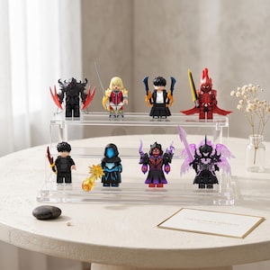 May include: A collection of eight fantasy-themed minifigures displayed on a two-tiered clear acrylic stand. The figures feature various armor, capes, and weapons, including swords and glowing energy effects in colors like red, blue, purple, and black.