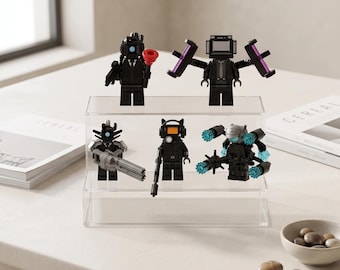 May include: Five black-clad minifigures displayed on a clear two-tiered acrylic stand. The figures feature various accessories including a red plunger, purple light bars, a grey multi-barreled weapon, and blue translucent energy components.