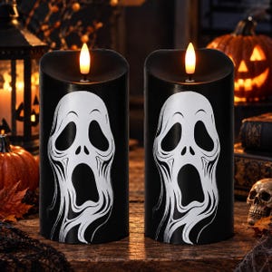 May include: Two cylindrical black LED candles featuring a white graphic of a screaming ghost face. Each candle has a realistic flame-shaped light at the top, creating a glowing effect against the dark wax surface.