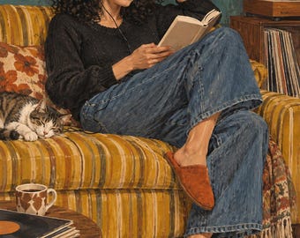 May include: A person with curly dark hair wears a black long-sleeved jumper, blue denim jeans, and brown suede slippers while reading a book. They wear beige over-ear headphones. A tabby cat sleeps on a yellow striped sofa next to them.