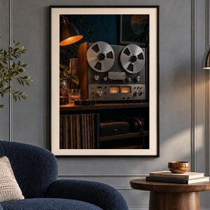 May include: A framed wall art print featuring a vintage reel-to-reel tape recorder with two large silver metal reels, illuminated analog VU meters, and various control knobs, set against a dark background with warm ambient lighting.