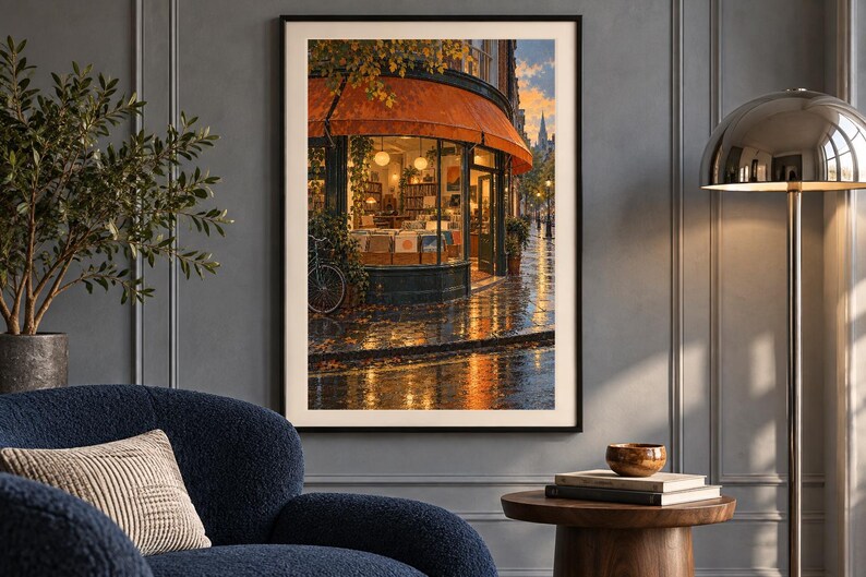 May include: A framed wall art print depicting a street-level view of a corner shop with a large orange awning, glowing interior lights, and a bicycle parked outside on a wet, reflective pavement during a sunset or twilight hour.