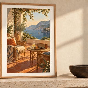 May include: A framed wall art print depicting a Mediterranean terrace with wicker furniture, a radio, and a glass carafe on a round table, overlooking a blue sea with mountains and sailboats under a clear sky with climbing vines.