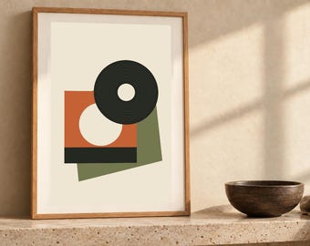 May include: A framed wall art print featuring a geometric composition on a cream background. The design includes a black circular ring, an orange square with a white circle cutout, a solid black rectangle, and an olive green rectangular shape.