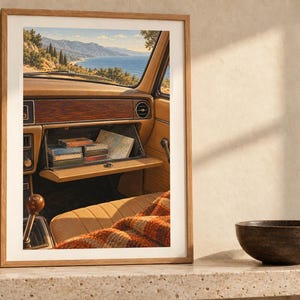 May include: A framed wall art print depicting the interior of a vintage car with an open glove compartment containing small rectangular items and a map, overlooking a coastal mountain landscape through the windshield.