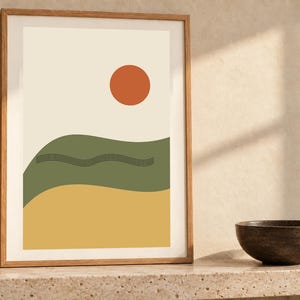 May include: A framed wall art print featuring a cream background with a solid orange circle at the top, a wavy olive green horizontal band in the center with thin black line details, and a solid yellow horizontal band at the bottom.