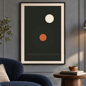 May include: A framed rectangular wall art print featuring a dark charcoal background with a central graphic of a vinyl record in black and orange, a white circle above it, and a row of thin vertical white lines along the bottom edge.