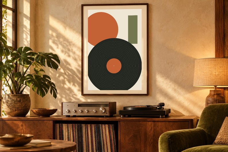 May include: A framed wall art print featuring a large orange circle, a vertical green rectangle, and a black vinyl record graphic with an orange center label, all arranged on a light cream background within a dark brown frame.