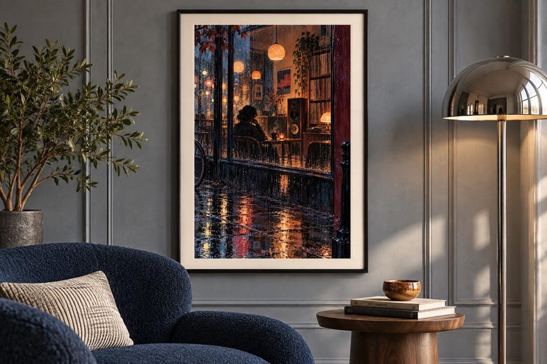 Puede incluir: Una impresi&oacute;n de arte mural enmarcada que representa una escena nocturna lluviosa vista a trav&eacute;s de una ventana. La obra muestra a una persona sentada dentro de un caf&eacute; c&aacute;lido y tenuemente iluminado con luces colgantes brillantes.